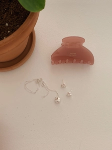 Flat lay of pink barrette, silver heart pendant necklace and matching stud earrings