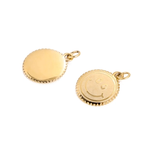 Close-up of golden smiley face metal pendants with gear-textured edges for DIY jewelry