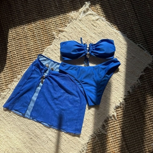 Bikini trois pièces bleu royal avec jupe en maille et boucles argentées de détail