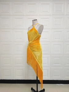 Détail de robe licou en velours jaune avec longues franges et ourlet asymétrique