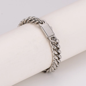 Silver stainless steel Cuban link bracelet for men on minimalist white display stand