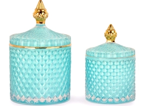 Close-up of turquoise glass jars with diamond relief texture and gold lids