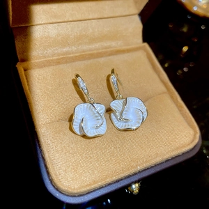 Detail of white enamel camellia flower earrings with gold plating and zircon inlay