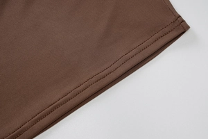 Vue détaillée des coutures haute densité sur le tissu marron foncé à coupe ajustée