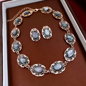 Vintage jewelry set with oval blue-grey resin stones and gold-tone embossed details