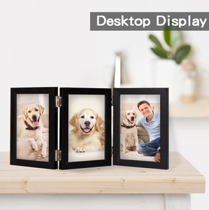 Close-up of triple folding wooden photo frame with black frame and metal hinges