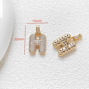 Detailed macro view of gold-plated letter H pendant with zircon and 16x30mm dimensions