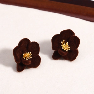 Detailed macro view of dark red velvet floral earrings with golden metal stamens