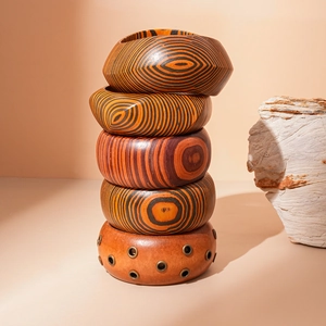 Five-piece stacked wood bangle set with concentric textures and metal rivet details