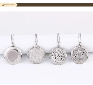 Detailed view of four stainless steel locket pendants with unique engraved patterns on chain