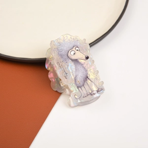 Detail of acetate hair claw clip featuring a cartoon poodle with pearlescent texture