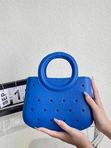 Gros plan du sac de plage EVA bleu klein avec trous circulaires et poignée ronde rigide