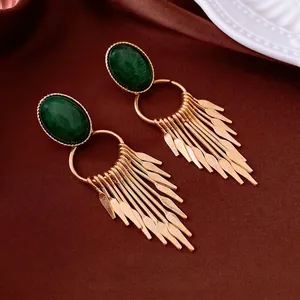 Vintage green oval gemstone earrings with elegant golden metal tassels on brown silk