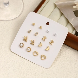 Set of six pairs of gold earrings with pearls, butterflies and moon shapes on card