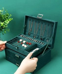 Detail view of dark green velvet jewelry box with multi-layer storage and necklace hooks