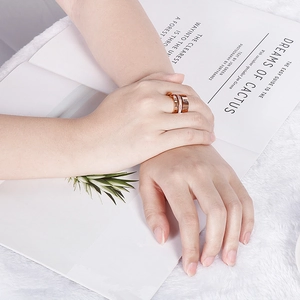 Close-up of rose gold Roman numeral rings with crystal inlay on a fashion model finger