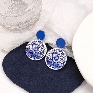 Macro detail of blue and white porcelain style earrings with elegant geometric patterns
