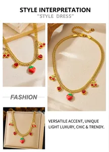 Detail of gold woven chain necklace with red strawberry and cherry heart pendants