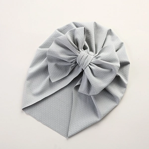 Close-up of light blue baby turban hat with waffle texture and large bow detail