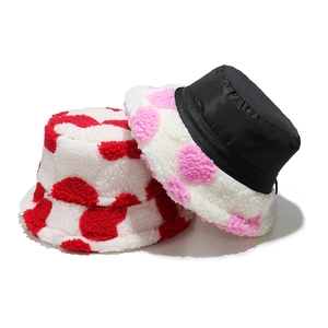 Detail of plush lamb wool bucket hats showing soft cow print texture and silky lining