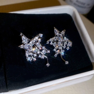 Gros plan de boucles d'oreilles étoiles en argent avec zircons dans un écrin en velours noir