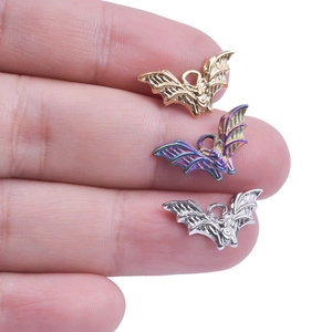 Macro view of small metal bat charms in gold, rainbow, and silver finishes for jewelry