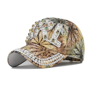 Luxury floral baseball cap with dense pearls and colorful rhinestones on a white background