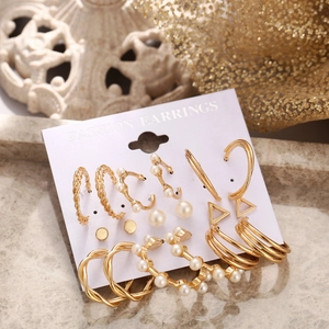 Close-up of a 9-piece vintage gold C-shaped earring set with faux pearl details