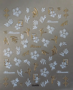 Macro shot of 3D embossed nail stickers with white flowers, gold leaves and pearls