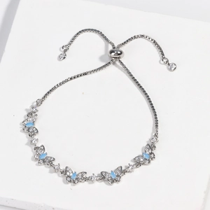 Detail of silver butterfly bracelet featuring blue gemstone and adjustable box chain