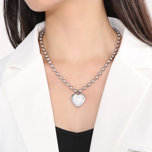 Gros plan d'un collier pendentif cœur en argent avec chaîne à billes sur un mannequin