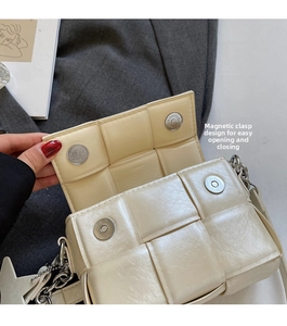 Détail du sac tressé crème avec fermoir magnétique argenté et bandoulière en chaîne