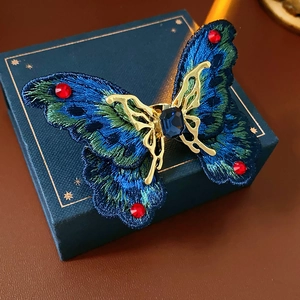 Macro detail of vintage butterfly ring with embroidery and sparkling gemstones