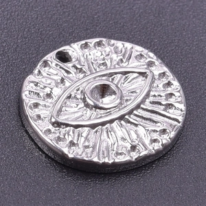Detailed view of silver stainless steel evil eye pendant with embossed sunburst texture