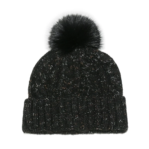 Close-up of black speckled knit beanie with a large faux fur pom-pom and folded cuff