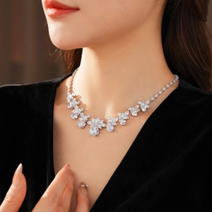 Close-up of silver floral necklace featuring a pear-cut zircon on a model wearing black