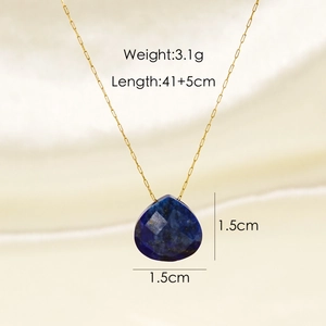 Close-up of teardrop lapis lazuli pendant with 18K gold chain on soft beige silk