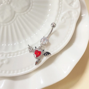 Silver devil bat heart belly ring with red zircon and crystal wings on white plate