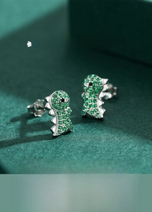 Détails macro des boucles d'oreilles dinosaure en argent S925 avec zircons verts pavés