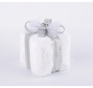 Close-up of white plush Christmas gift box ornament with silver ribbon and crystal detail
