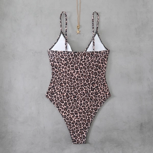 Flat lay of a leopard print one-piece swimsuit with deep V-neck and golden starfish detail