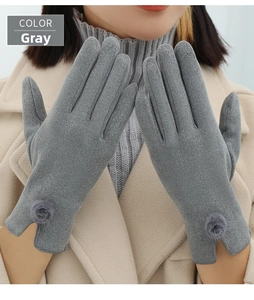 Detail of grey winter gloves featuring warm faux suede material and cute pompom trim