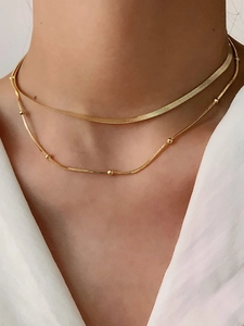 Detail of 14K gold plated layered necklace showing snake chain and bead chain on neck