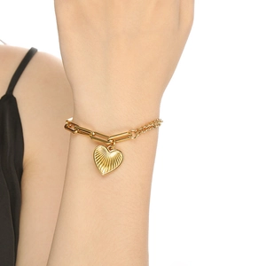 Gold 18K plated stainless steel heart bracelet with sunburst texture on model wrist