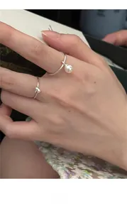 Detail of 925 sterling silver heart ring and pearl pendant ring set on finger
