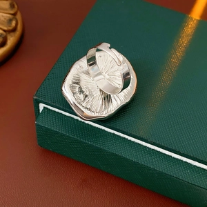 Macro shot of a minimalist silver resin ring with adjustable wide band on green jewelry box