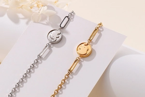 Macro shot of gold and silver elephant charm bracelets on a geometric display stand