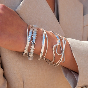 Detail of silver irregular geometric twisted bracelets and chain set on a model