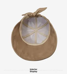 Close-up of khaki sun hat interior with breathable white mesh lining and bow detail