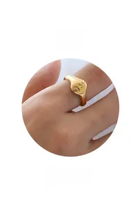 Close-up of a wide vintage gold chain ring with embossed patterns worn on finger